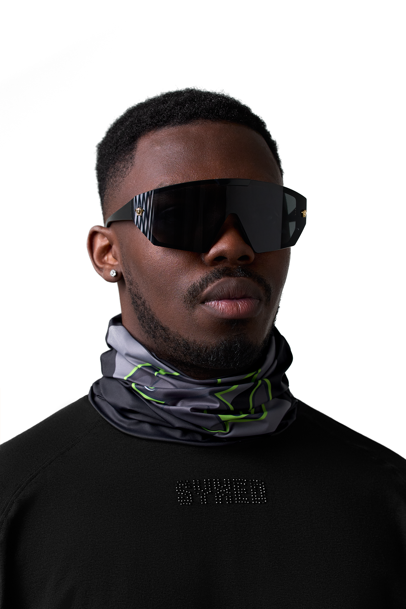 Man wearing neck gaiter and a black shirt with text, against a white background