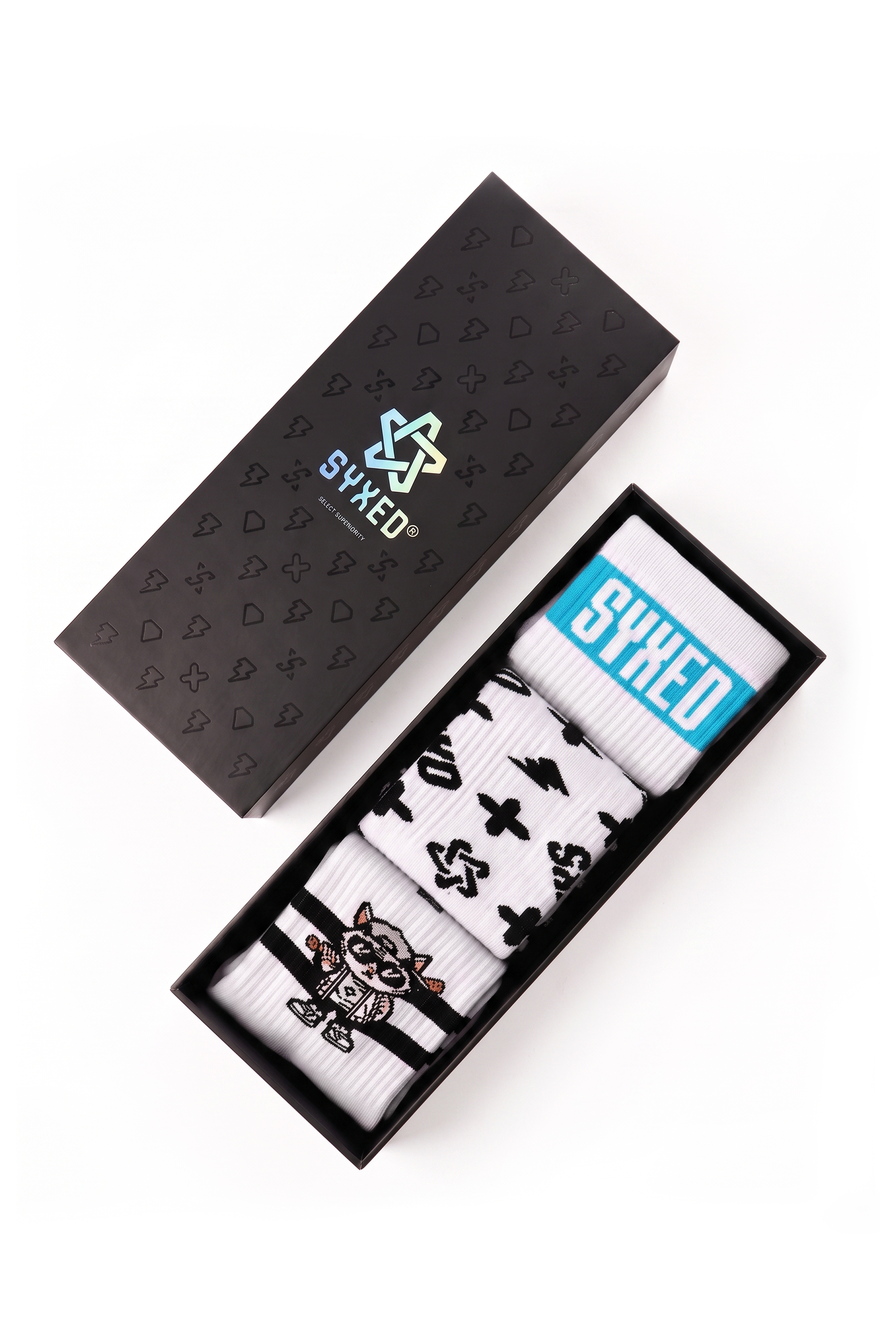 A boxed pair of white socks with black graphic prints and a bright blue SOCKER band reading 'SYXED', displayed next to a black branded presentation box on a white background.