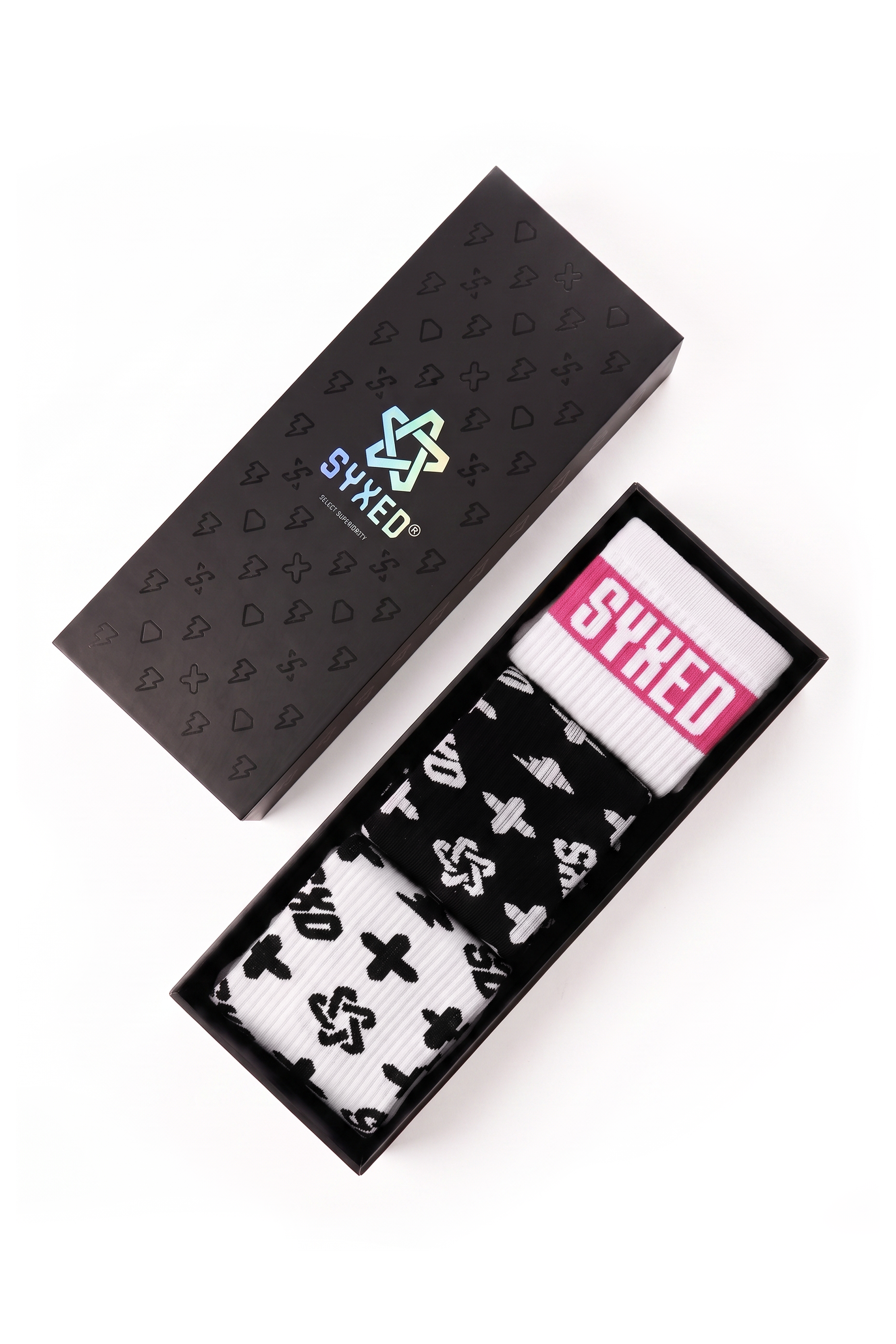 Black patterned socks in a black presentation box next to their black packaging lid, which features the SYXED logo.