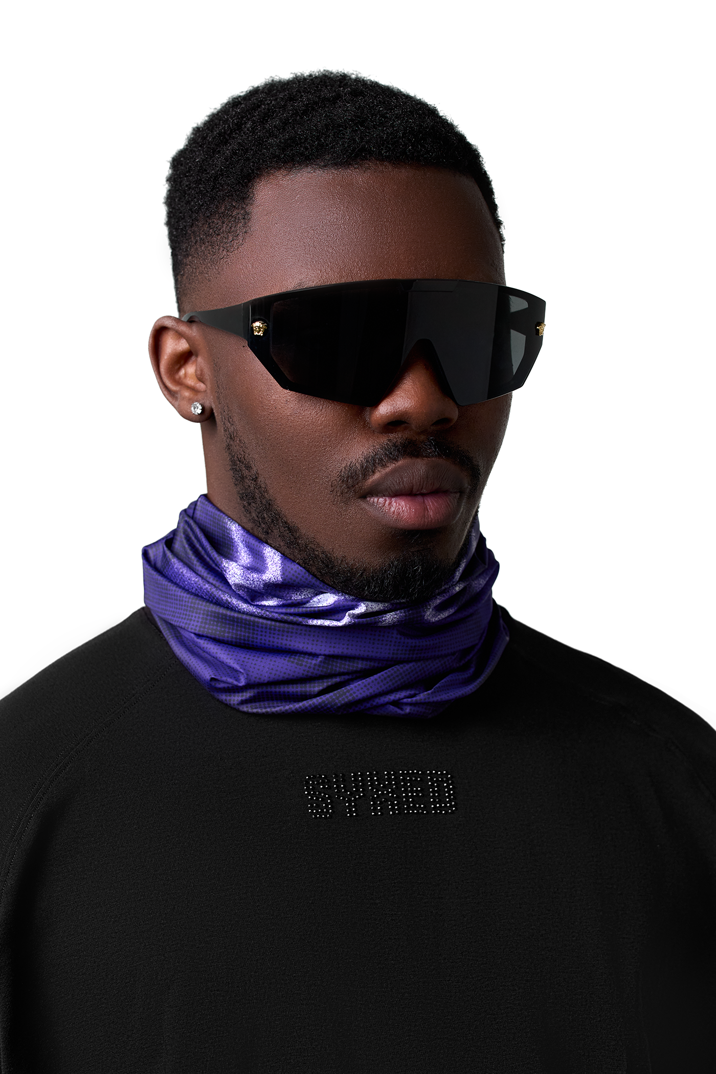 Man wearing black sunglasses and a purple neck gaiter with 'SYXED' branding on a white background