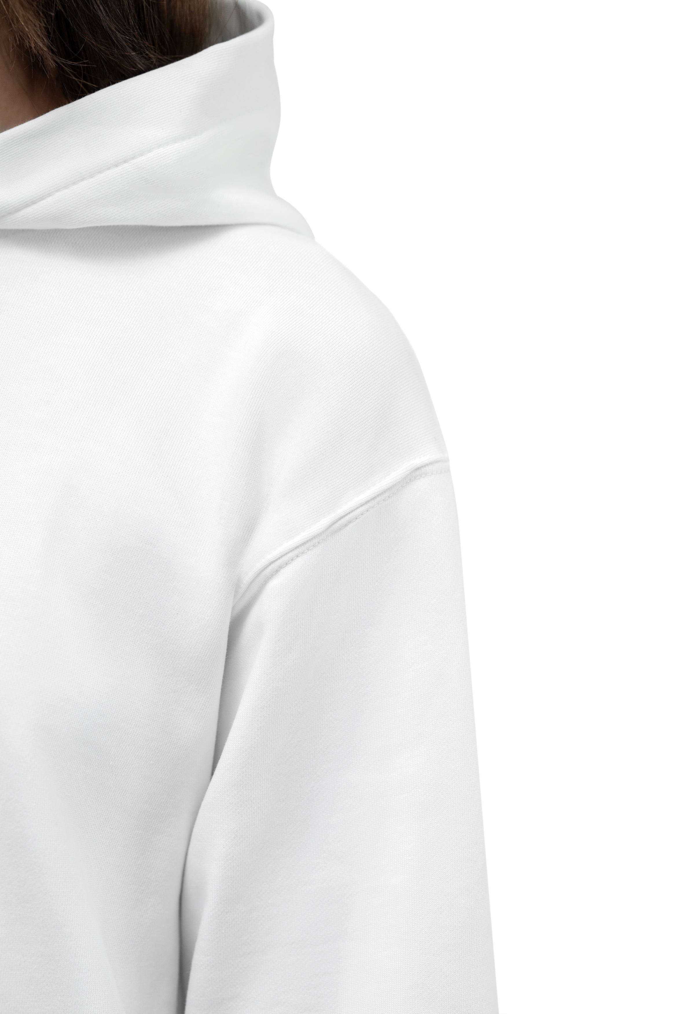 Close-up of a white hooded sweatshirt showing the shoulder, sleeve, and part of the neck area against a plain white background.